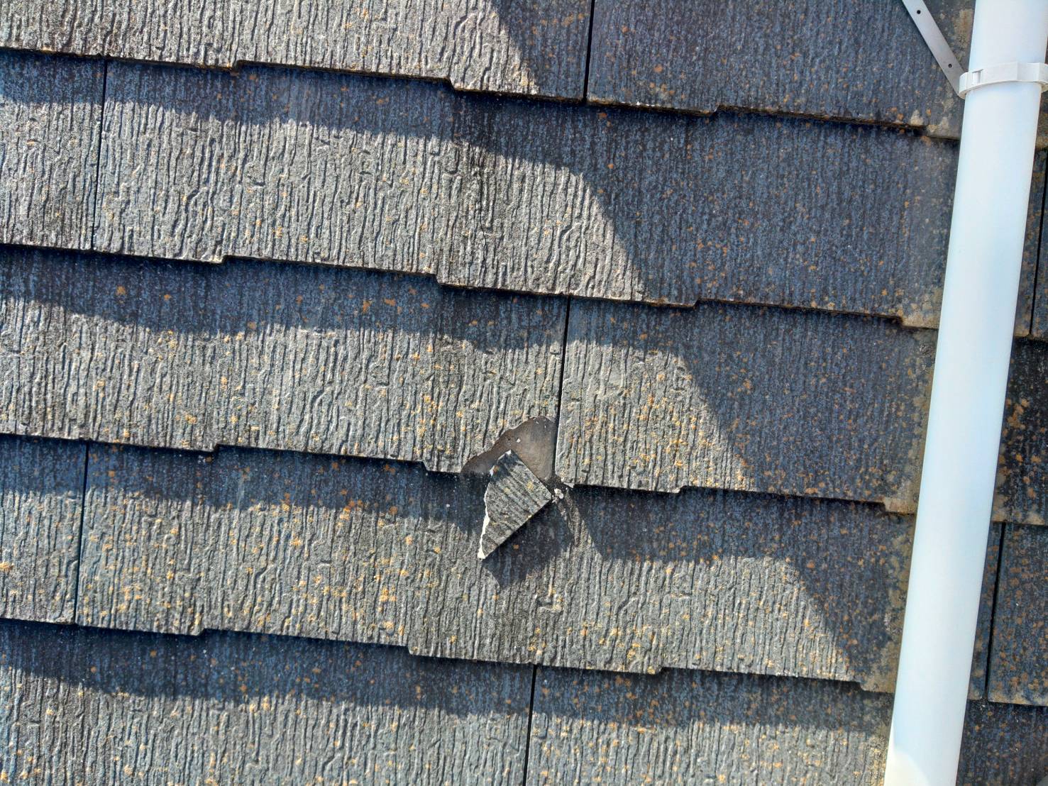 スレート屋根が欠けて破片が見えてしまっている