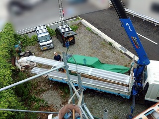 新しい屋根材をクレーンで運搬している様子