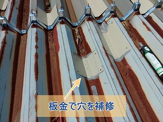 板金で折板屋根倉庫の穴を補修している様子