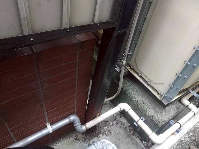 塀の支柱の根元部分が錆びて穴が開いている状態