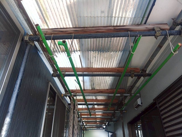 施工前の住宅に隣接した変色が見られるポリカ屋根の様子