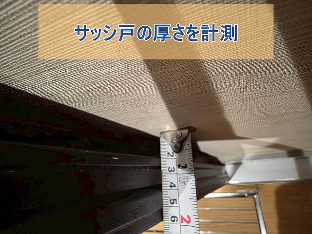 サッシ戸の厚さを計測している様子