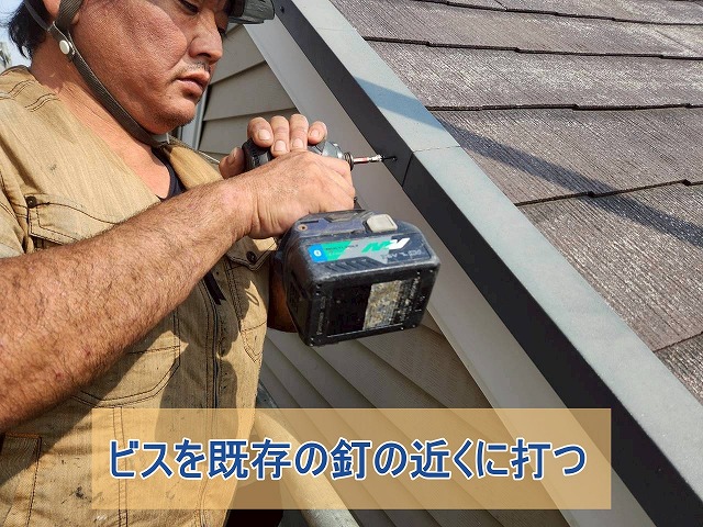 ケラバの新しいビスを既存の釘の近くに打っている様子