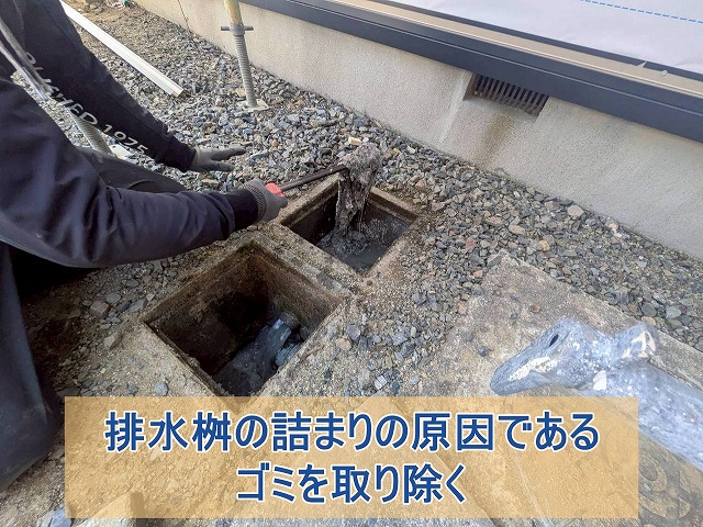 排水桝の詰まりの原因であるゴミを取り除いている