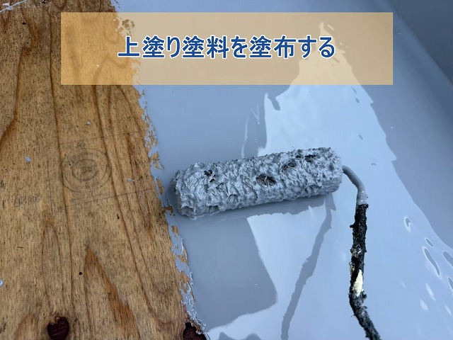 玄関上の庇に下塗りを施した後に上塗り塗料を塗布する