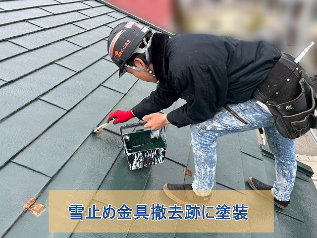 雪止め金具撤去跡に塗装をしている様子