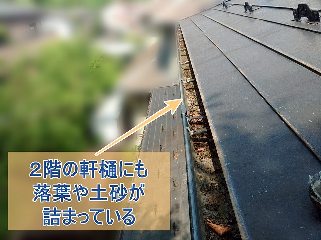 住宅２階部分の軒樋に落ち葉や土砂が溜まっている様子